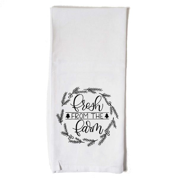 White Floursack Kitchen towel with black hand illustrated design that says fresh from the farm with twigs and berries in a wreath shape