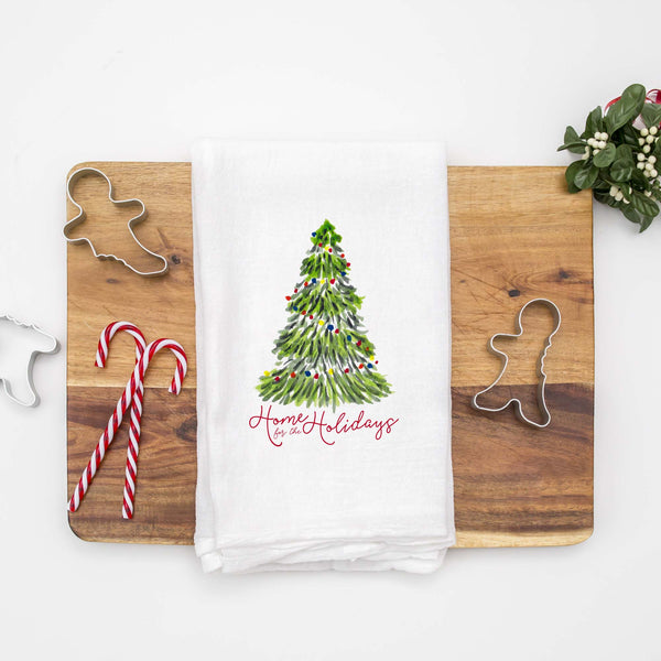 Floursack Kitchen Tea Towel with a watercolor Christmas tree with colorful lights that says home for the holidays