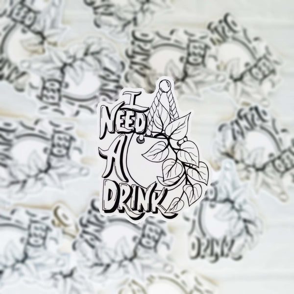 3" black and white illustrated hand lettered vinyl sticker says I need a drink with an illustrated hanging pothos plant