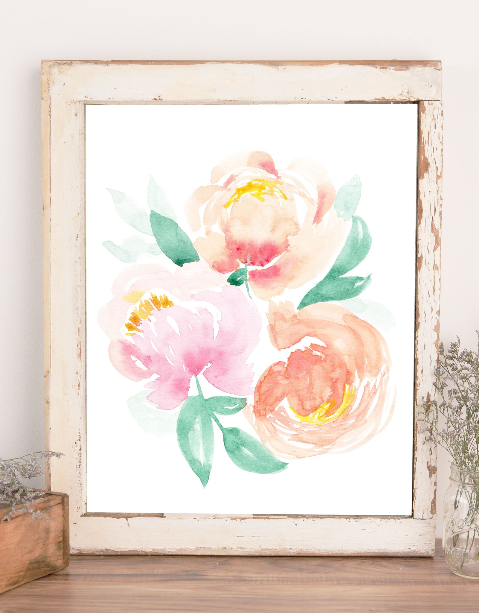 Wall art of three watercolor painted peonies in pinks and peaches with green leaves