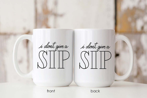 15oz white ceramic mug with hand lettered illustrated design that says I don't give a sip showing both the front and back of the mug